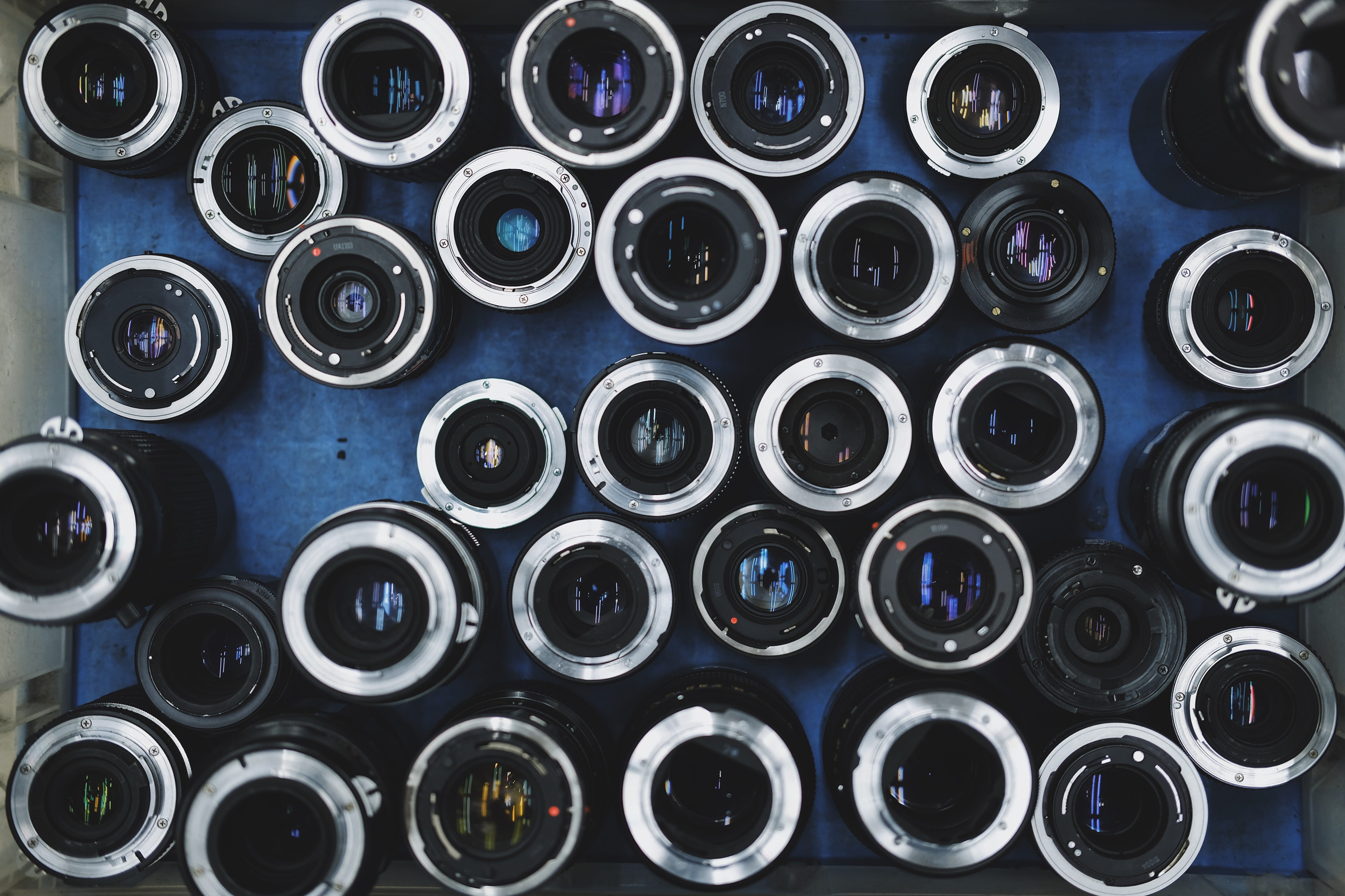 A collection of camera lenses laid out on a table upside down.