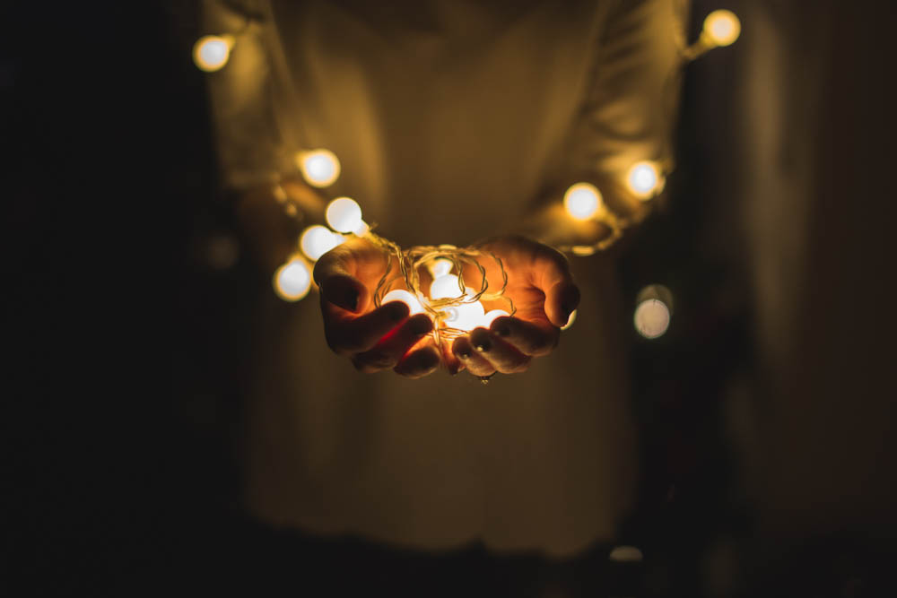 Dark image of a person holding a candle