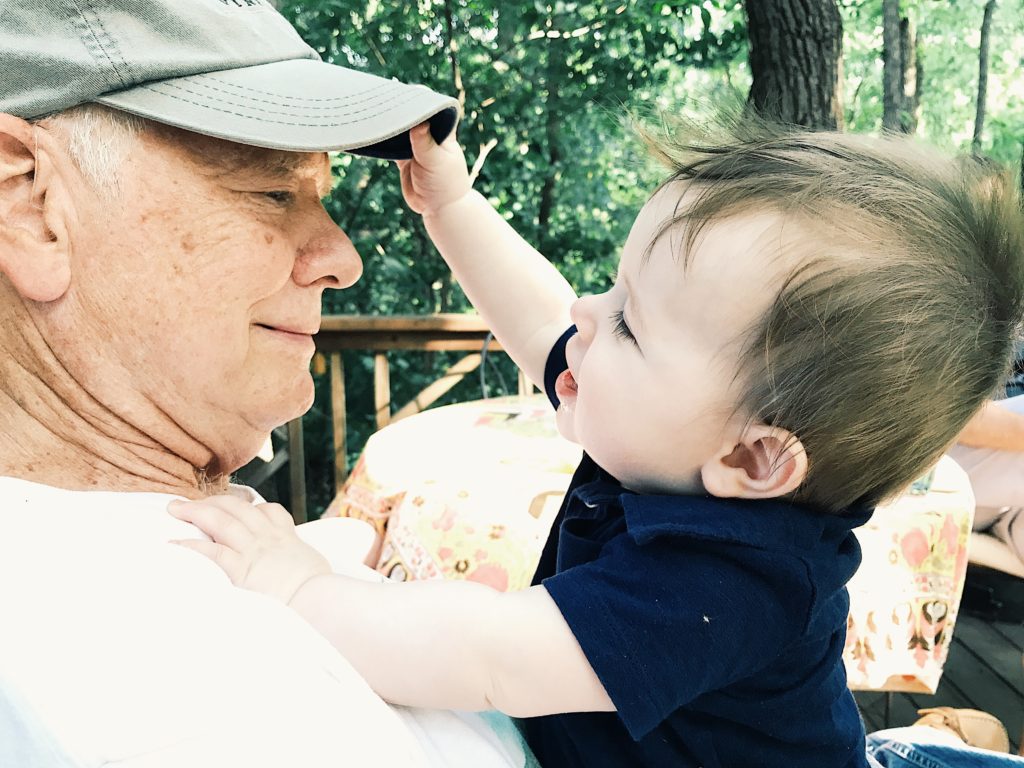 Image of baby grabbing grandpa's hat in outdoor setting shot with the iPhone 7 Plus