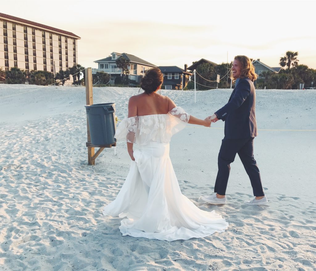 Image of a backlit couple leaving their wedding ceremony and smiling at each other photographed with the iPhone 7 Plus camera