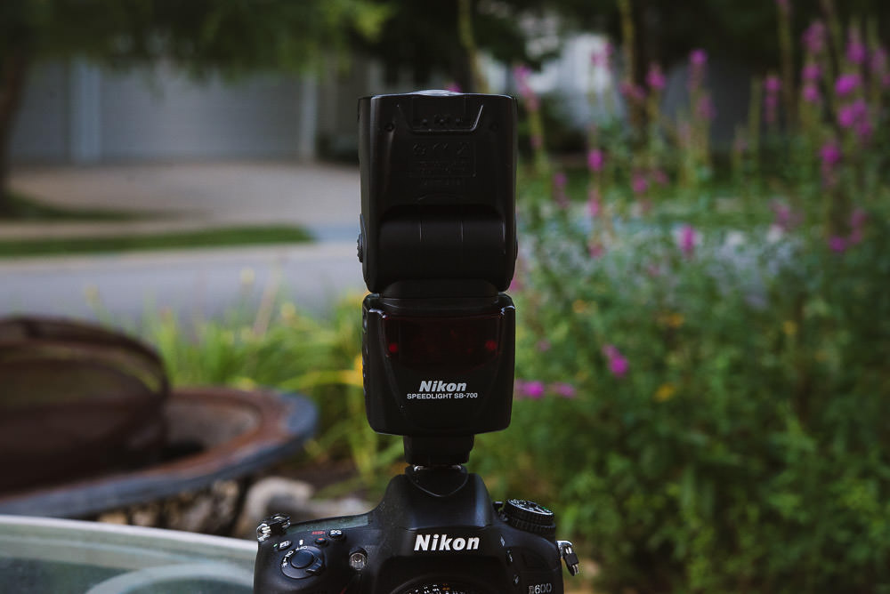 Image of the Nikon SB-700 Hot Shoe Flash on Top of a Nikon camera with the flash head pointed up, as you would do when you want to bounce flash