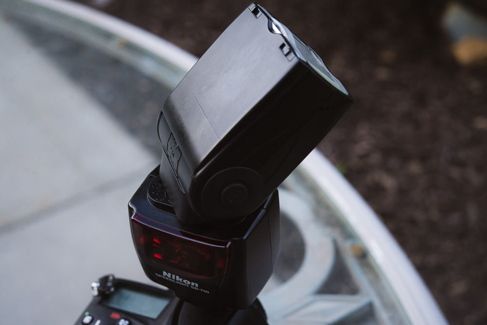 Image of a Nikon hot shoe flash pointed up and at an angle to show how to do one of the best bounce flash techniques