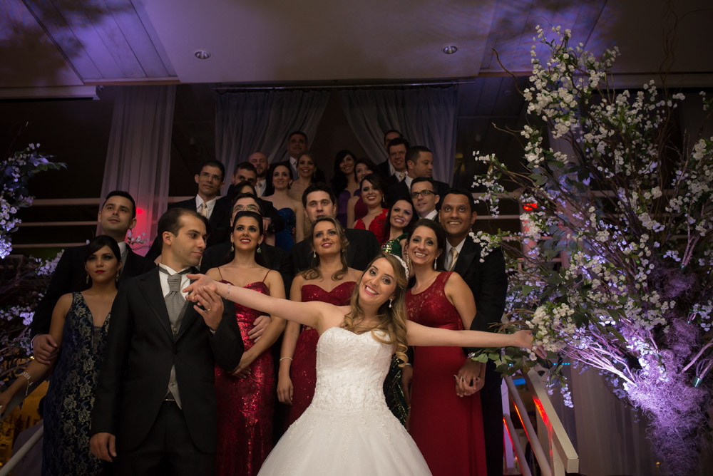 image of bride smiling and joking in front of wedding group