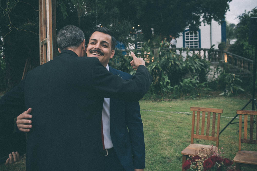 Image of a groom hugging a priest before the start of a wedding ceremony