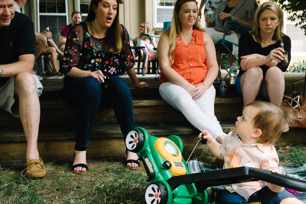 image of a one year old at his first birthday party playing with a toy