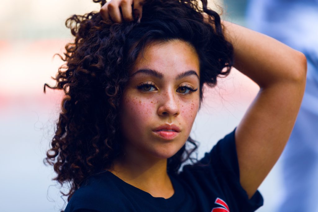 image of a woman with tan skin and curly hair with a blurred background effect