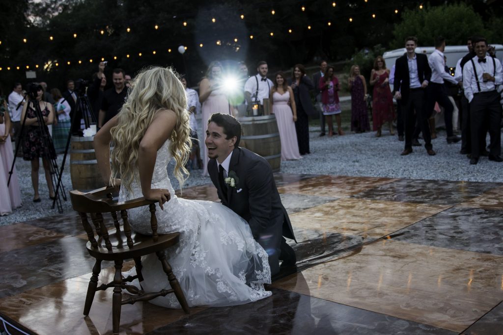 Photo of a bride and groom looking at each other and laughing on the dance floor of their wedding reception