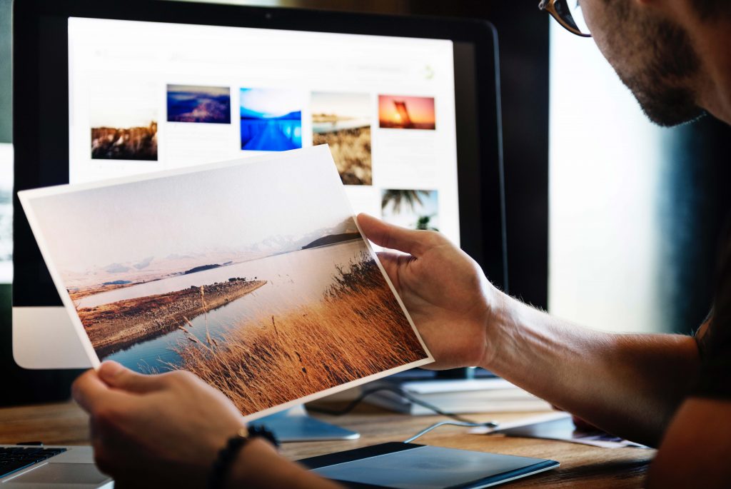 Image of someone looking at a printed picture of a landscape