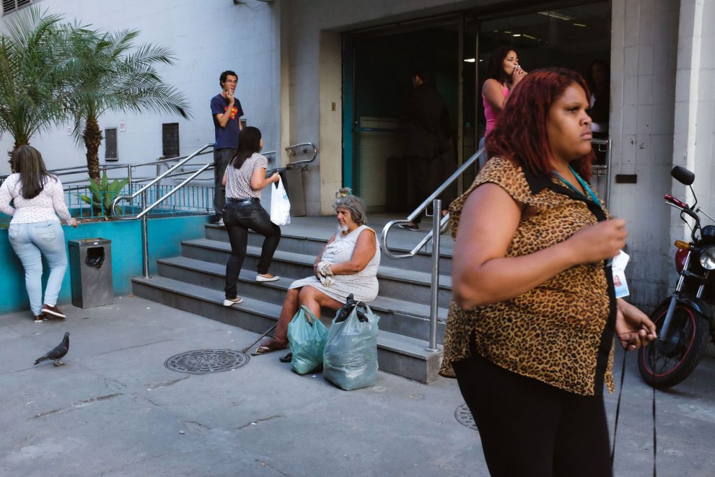 Street photography image with multiple subjects in front of a business building shot with a 35mm equivalent lens