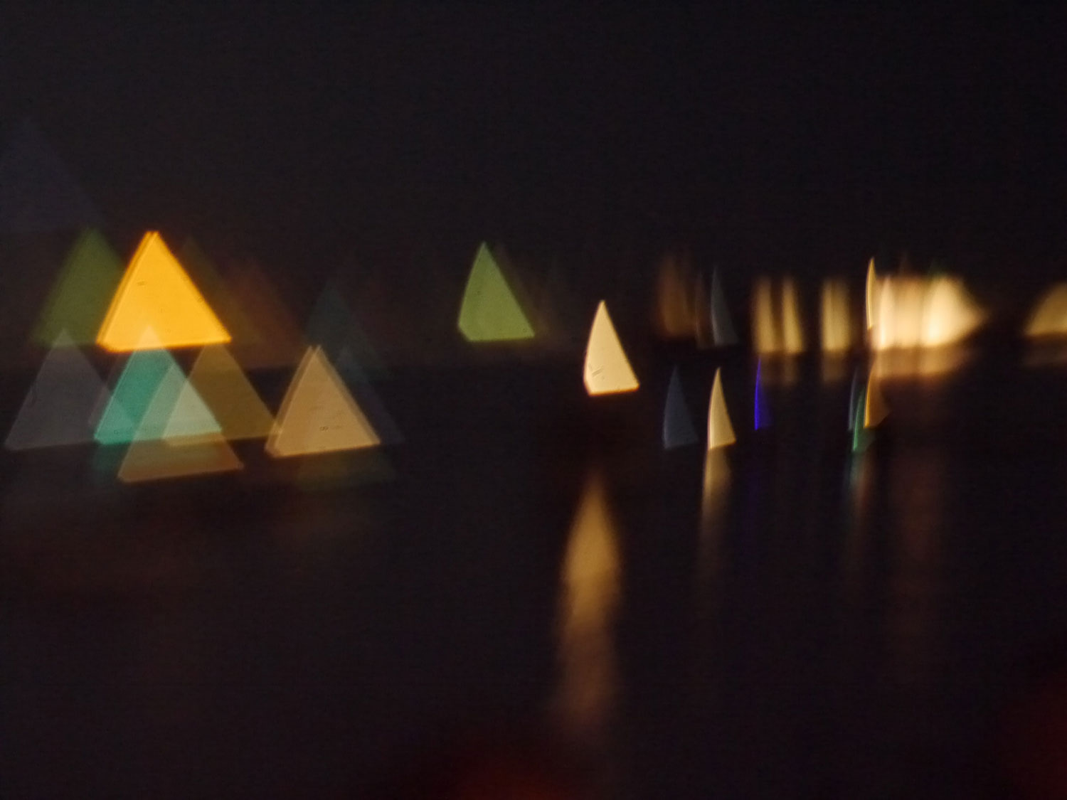 Abstract lights on a black background in the form of triangles.