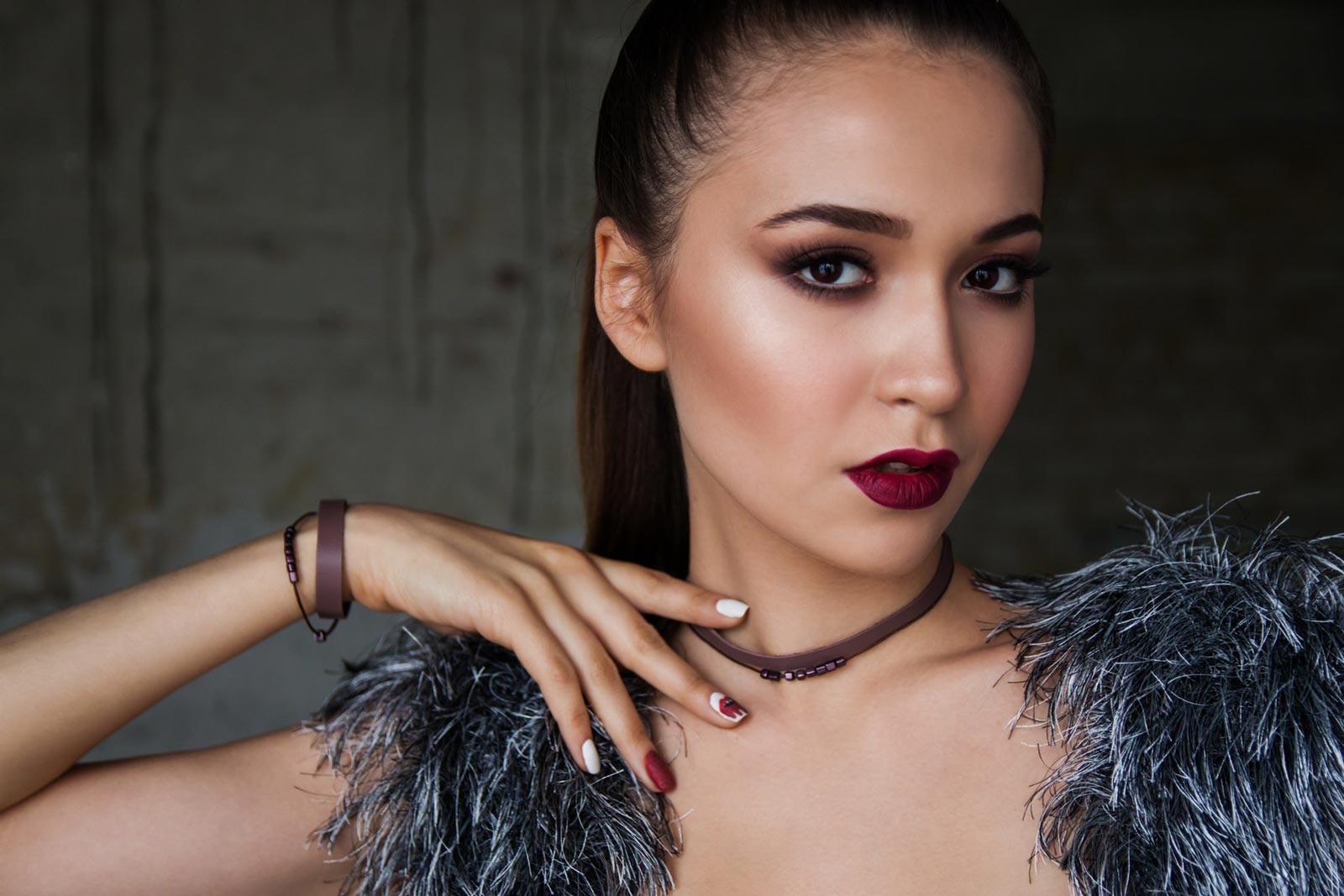 A brunette woman posing with her hand on her shoulder.