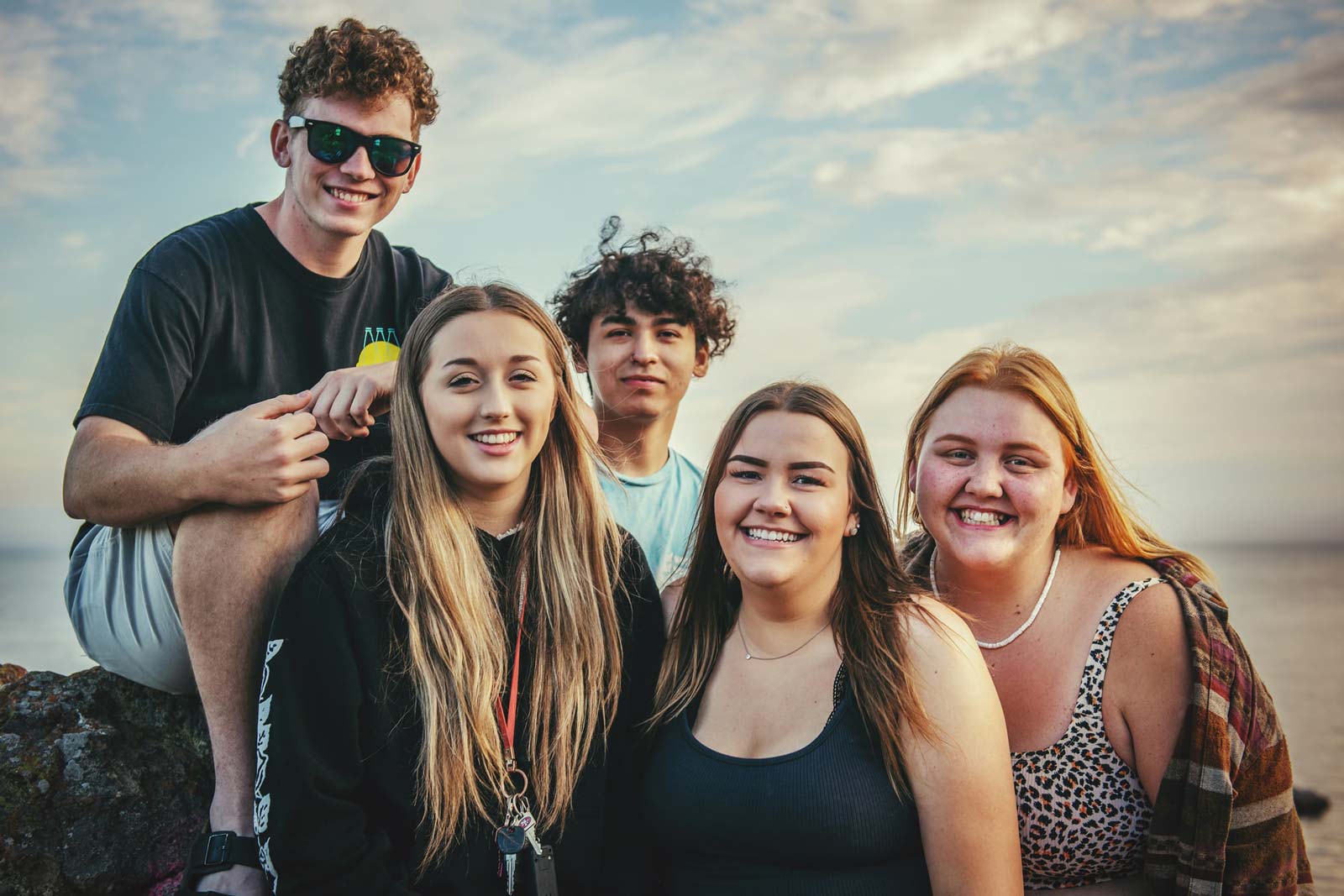 A portrait of a group of three young women and two young men.