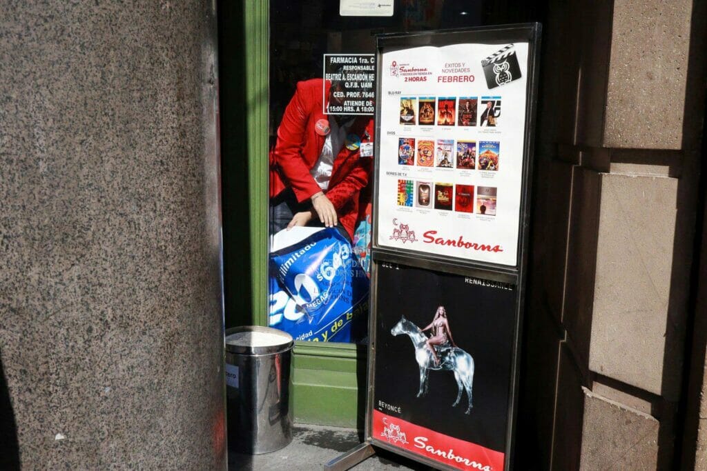 A storefront with a person putting up a sign