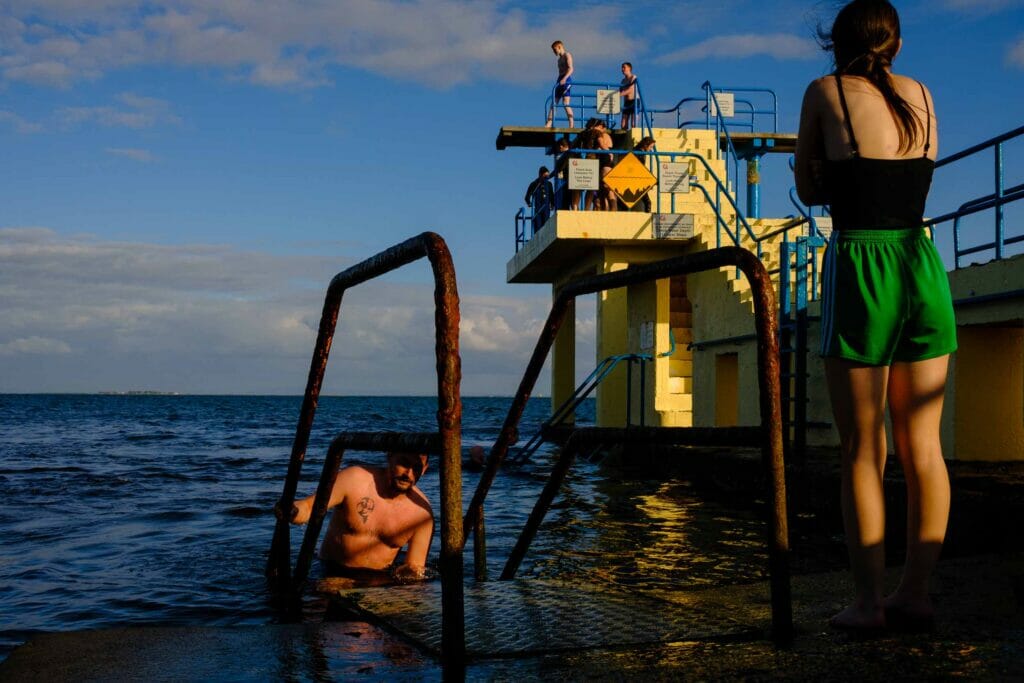 People jumping off a yellow diving platform