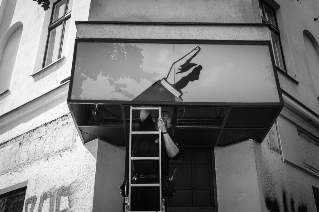A man working on a building display that has a hand pointing.