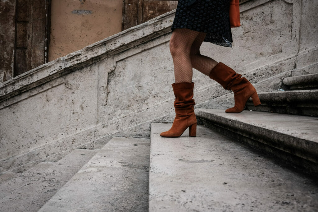 A woman's legs walking down a stone staircase.