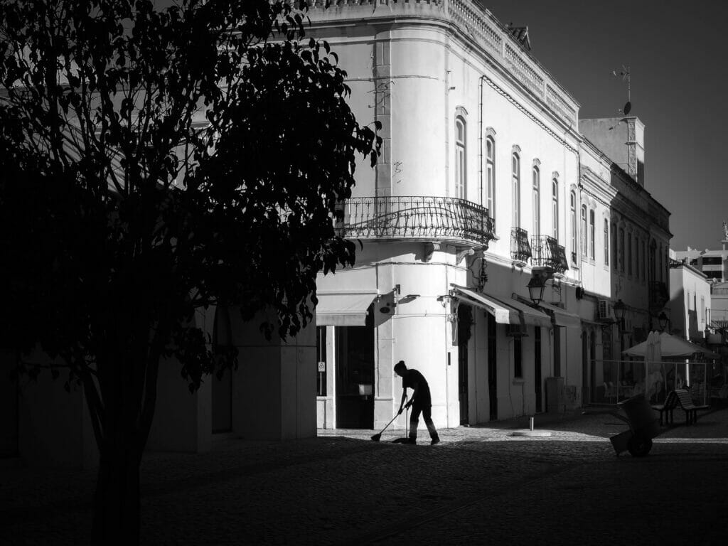 A person sweeping a city street.