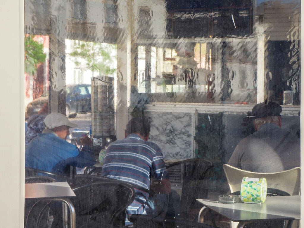 Three men in a cafe from behind.