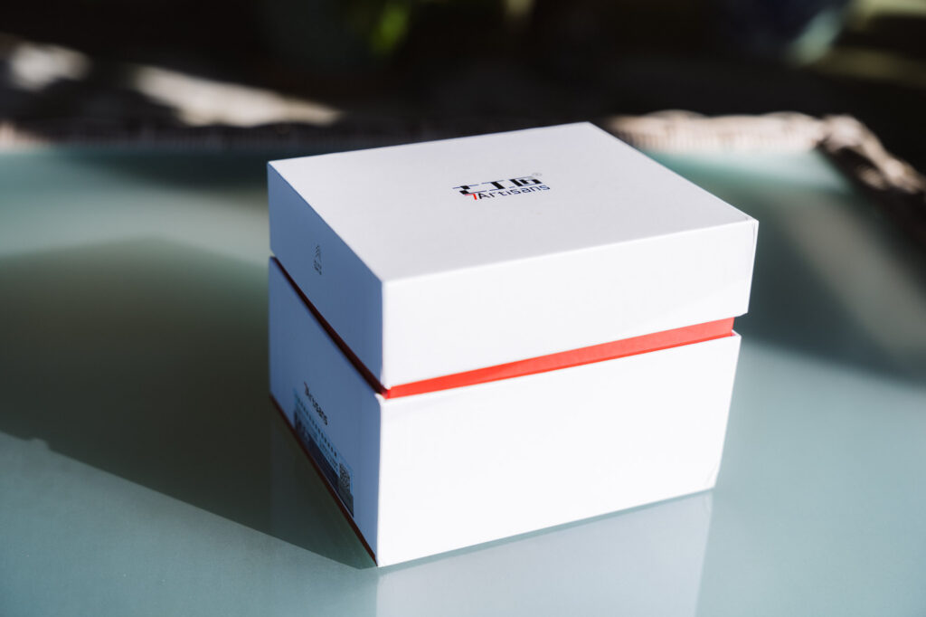 A white 7Artisans lens box on a glass table.